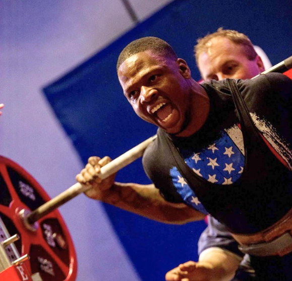 Powerlifter under a loaded barbell during a max-effort squat